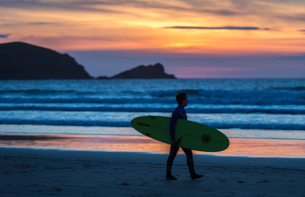 A surfer on a beach in Newquay in Cornwall, England